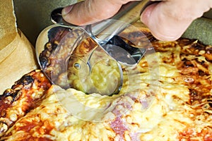 Cutting ham and cheese pizza