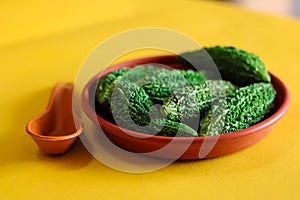 Cutting karela with yellow background,top view of bitter gourd on market - Bitter melon,bitter gourd in the basket,copy space with