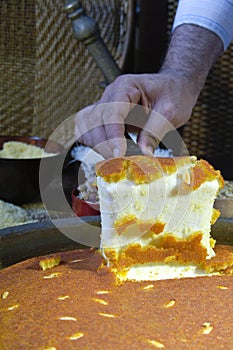 Cutting Kunafa or Kinafa, Arabic Sweets with Cheese for Ramadan a photo