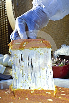 Cutting Kunafa or Kinafa, Arabic Sweets with Cheese for Ramadan a