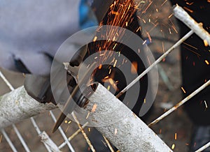 Cutting metal pipe with grinder circular saw electric tool sparks