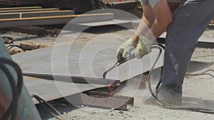 Cutting metal products with a gas cutter, the worker cuts a metal sheet with a gas cutter, cut metal close-up