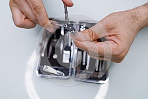 Cutting the nail with professional manicure scissors. A man gives himself a manicure