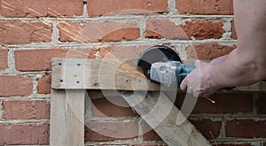 Cutting nails with a grinder in men`s hands