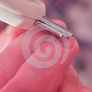 Cutting nails with special scissors on the fingers of a newborn baby, children manicure and cutting burrs