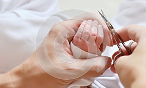 Cutting newborn baby nails with scissors