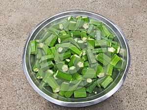 Cutting Okra / lady finger in the bowl.