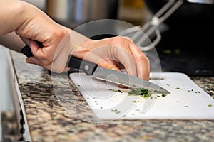 cutting the parsley on the white kitchen board