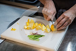 Cutting the patissons with a knife. Cook in a restaurant.