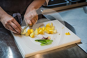 Cutting the patissons with a knife. Cook in a restaurant.