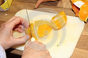 Cutting a peeled orange with sharp knife