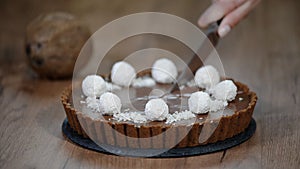 Cutting a piece of chocolate coconut tart.