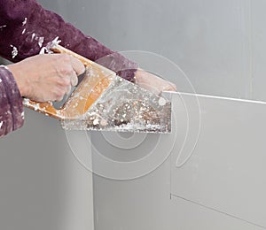 Cutting plasterboard plaster hand dirty saw