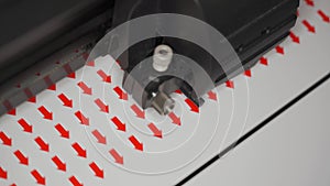 Cutting plotter machine making small round red arrows stickers, closeup detail