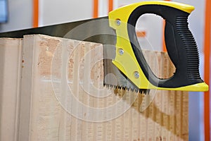 Cutting porous ceramic block with hand saw