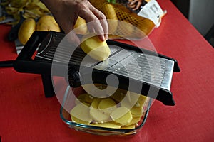 Cutting potatoes with a kitchen mandolin
