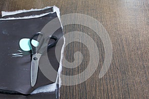 Cutting of the product for sewing. On the table is a cloth with chalk-marked garments. Just lie scissors and chalk.