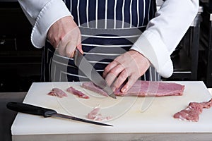 Cutting raw meat with knife