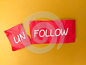 Cutting red paper with the word UNFOLLOW