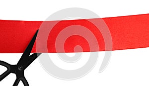 Cutting red ribbon with scissors on white background