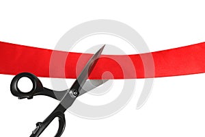 Cutting red ribbon with scissors on white background