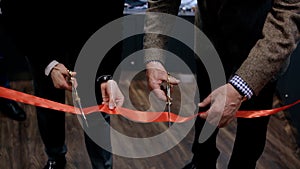 Cutting the ribbon during the special event or the opening, new start and beginning of success. Video. Close up of