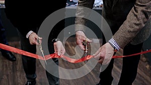 Cutting the ribbon during the special event or the opening, new start and beginning of success. Video. Close up of