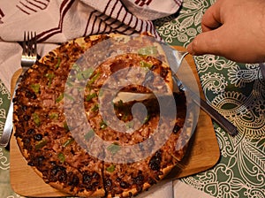 Cutting and separating a piece of freshly baked pizza photo