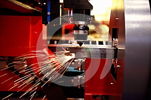 Cutting of sheet metal. Sparks fly from laser by automatic cutting CNC, PLC machine.