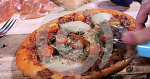 Cutting a slice of a Italian pizza margherita