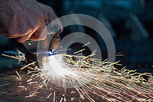 Cutting steel blanks with hand plasma, a large number of bright sparks, welding and metal processing