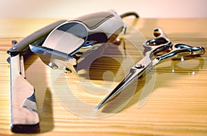 CUTTING TOOLS OF A BARBER ON WOODEN BACKGROUND