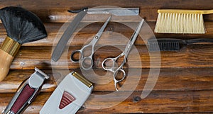 CUTTING TOOLS OF A BARBER ON WOODEN BACKGROUND