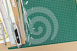 cutting tools on working desk - utility knife, metal ruler, pencil