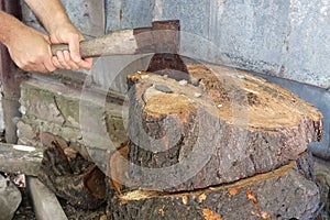 Cutting wood with a large sharp ax, Man Chops firewood, Chopping of wood on a wooden log in summer at the home