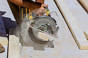 Cutting wooden beams with handsaw by a woodworking carpenter photo