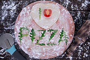 Cutting wooden board with traditional pizza ingridients on dark background, top view