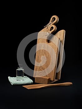 Cutting wooden boards on stand and kitchen spatula onblack background. Items for the kitchen studio shot