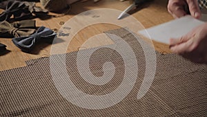 Cutting wool fabric. the line pattern. Bow ties of woolen fabric. Young man working as a tailor and using a sewing