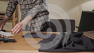 Cutting wool fabric. the line pattern. Bow ties of woolen fabric. Young man working as a tailor and using a sewing