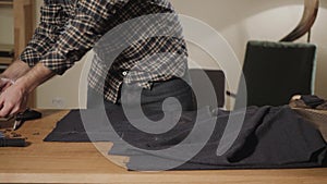 Cutting wool fabric. the line pattern. Bow ties of woolen fabric. Young man working as a tailor and using a sewing