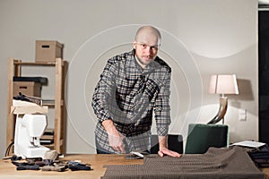 Cutting wool fabric. the line pattern. Bow ties of woolen fabric. Young man working as a tailor and using a sewing
