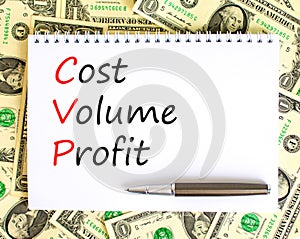 CVP cost volume profit symbol. Concept words CVP cost volume profit on white note on beautiful background from dollar bills. Pen.