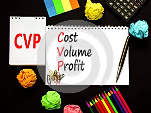 CVP cost volume profit symbol. Concept words CVP cost volume profit on white note on beautiful black background. Pencil and pen.