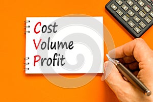 CVP cost volume profit symbol. Concept words CVP cost volume profit on white note on beautiful orange background. Businessman hand