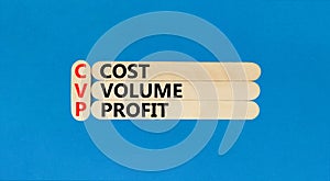 CVP cost volume profit symbol. Concept words CVP cost volume profit on wooden stick on a beautiful blue table blue background.