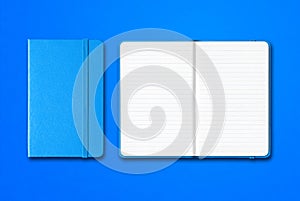 Cyan closed and open lined notebooks isolated on blue background