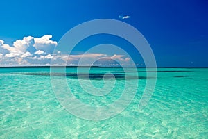 Cyan ocean under blue sky with clouds