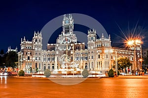 Cybele palace and fountain on Cibeles square at night, Madrid, Spain photo