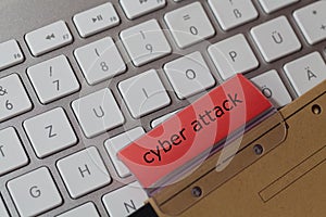 Cyber attack as a term on a red tab of a brown hanging file on a computer keyboard